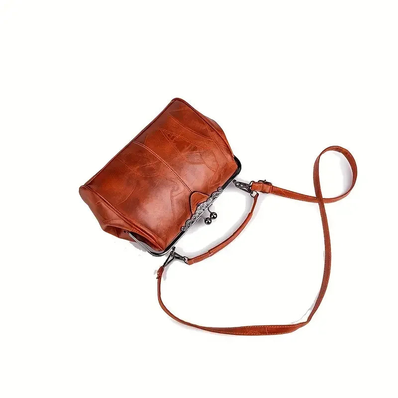Brown leather crossbody bag with metal clasp and long shoulder strap on white background