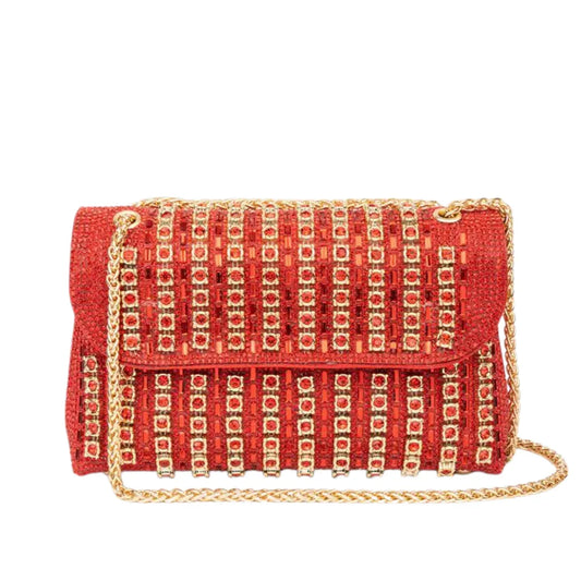 Red embellished clutch bag with gold stud accents and gold chain strap on white background