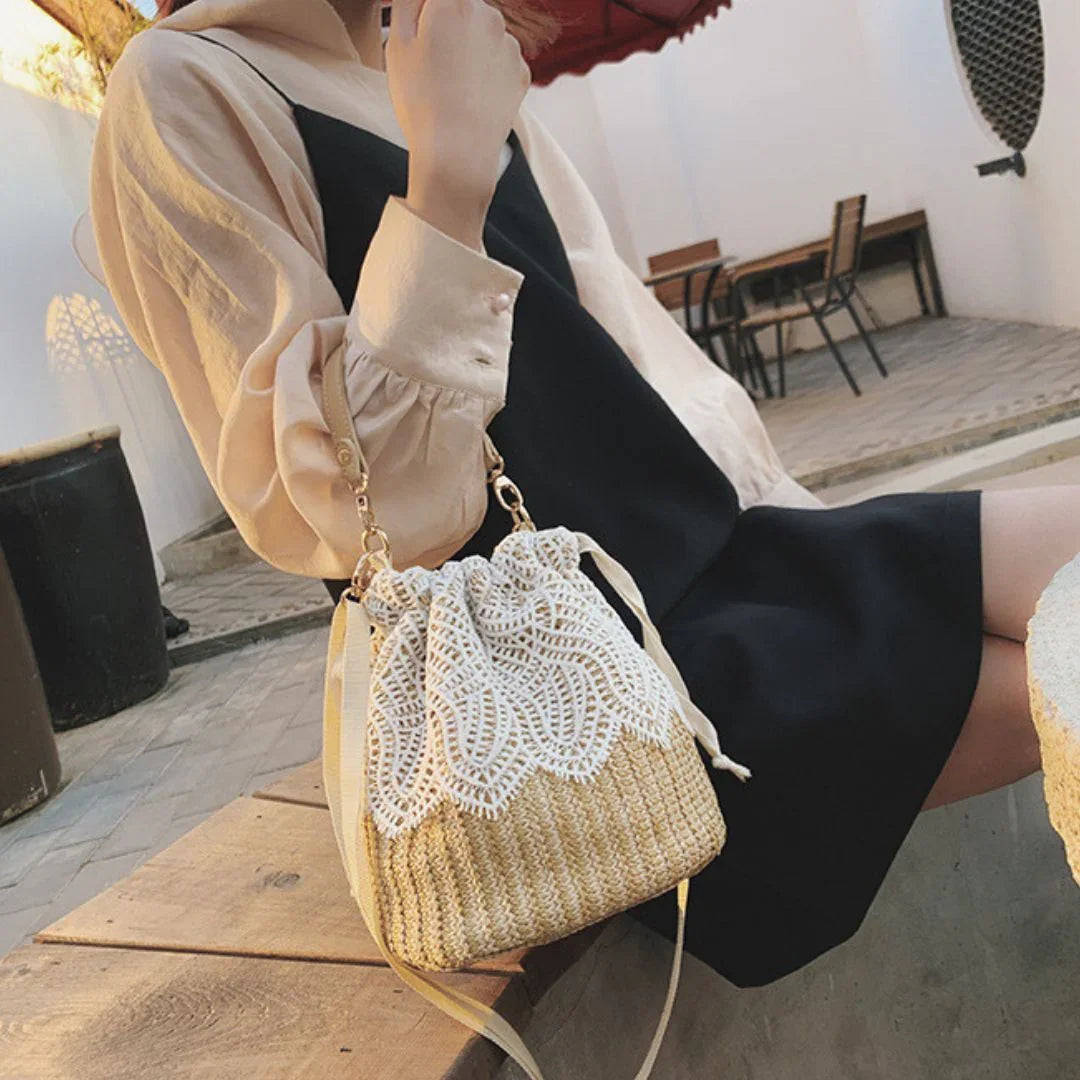 Woman with woven straw lace bucket bag in outdoor cafe setting