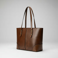 Brown leather tote bag with double handles on white background