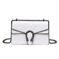 White crocodile-embossed leather shoulder bag with black chain strap and decorative metal clasp