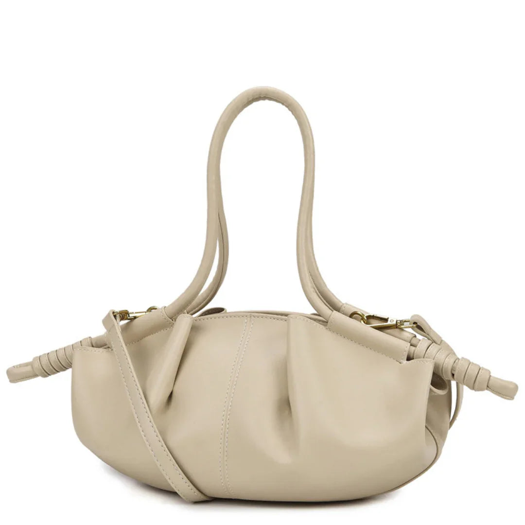 Beige leather handbag with knotted handles and gathered design on white background