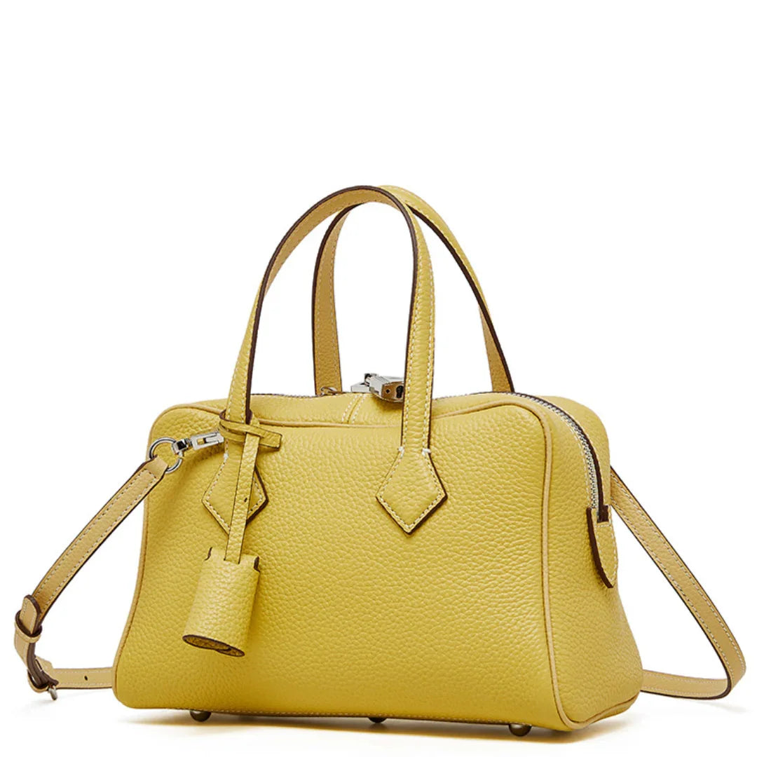 Yellow leather handbag with double handles and detachable shoulder strap on white background