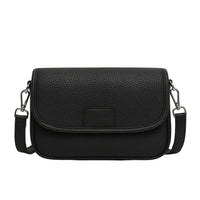 Black textured leather crossbody bag with flap closure and silver hardware on white background