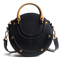 Round black leather handbag with gold hardware and top handle on white background