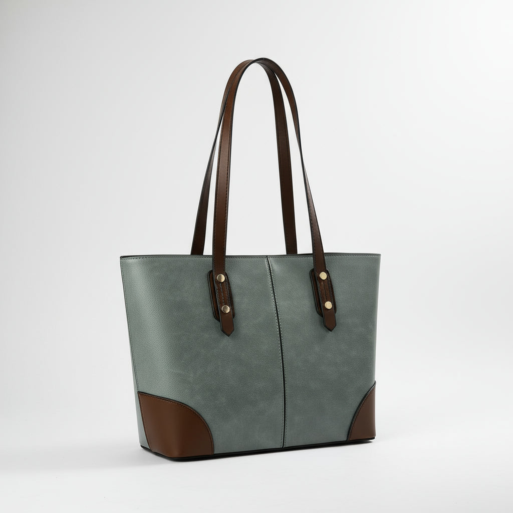 Green and brown leather tote bag with long handles on plain background
