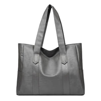 Large gray leather tote bag with double handles on a white background