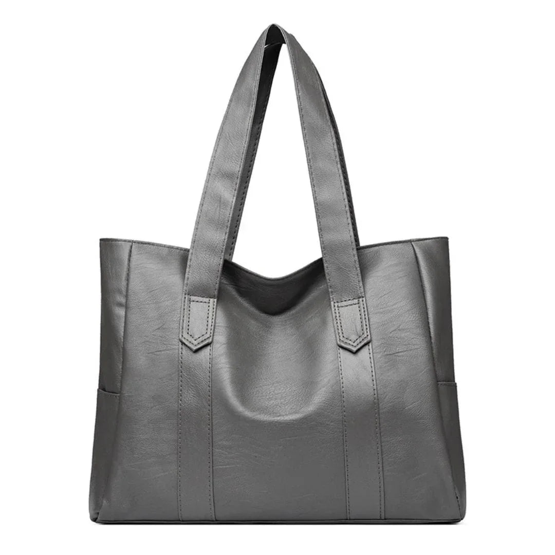 Large gray leather tote bag with double handles on a white background