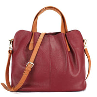 Two-tone leather handbag in burgundy and tan with shoulder strap on white background
