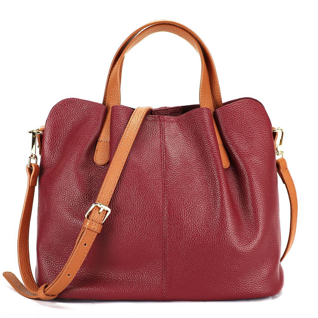 Two-tone leather handbag in burgundy and tan with shoulder strap on white background