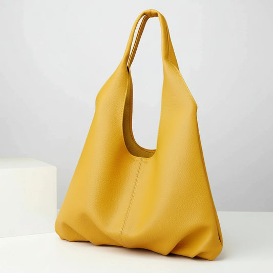 Yellow leather tote bag with wide handle on white background