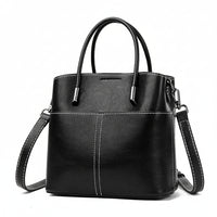 Black leather handbag with white stitching, top handles, and a detachable shoulder strap