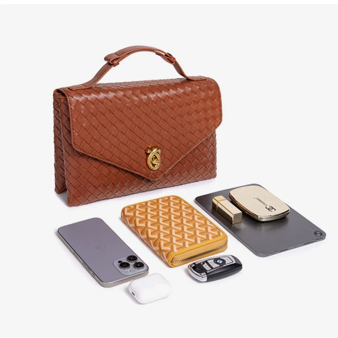 Brown woven leather handbag with phone, wallet, car key, tablet, AirPods, and compact on white