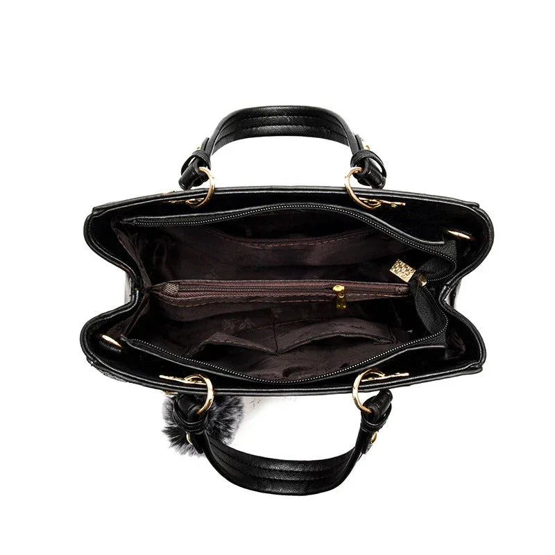 Black leather handbag interior with multiple compartments and gold hardware