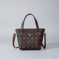 Brown patterned leather handbag with two top handles and a detachable shoulder strap on a gray background