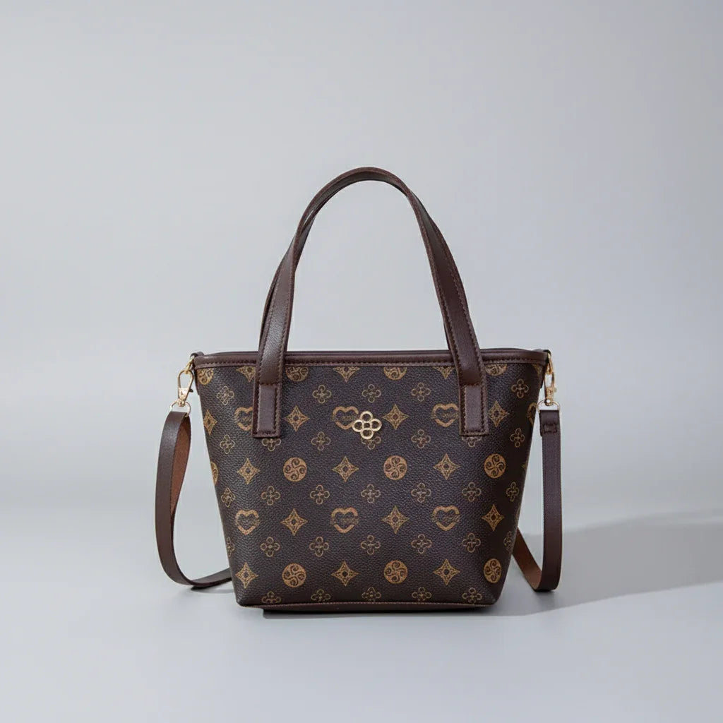 Brown patterned leather handbag with two top handles and a detachable shoulder strap on a gray background