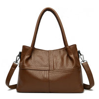 Brown leather handbag with double handles and a detachable shoulder strap on white background