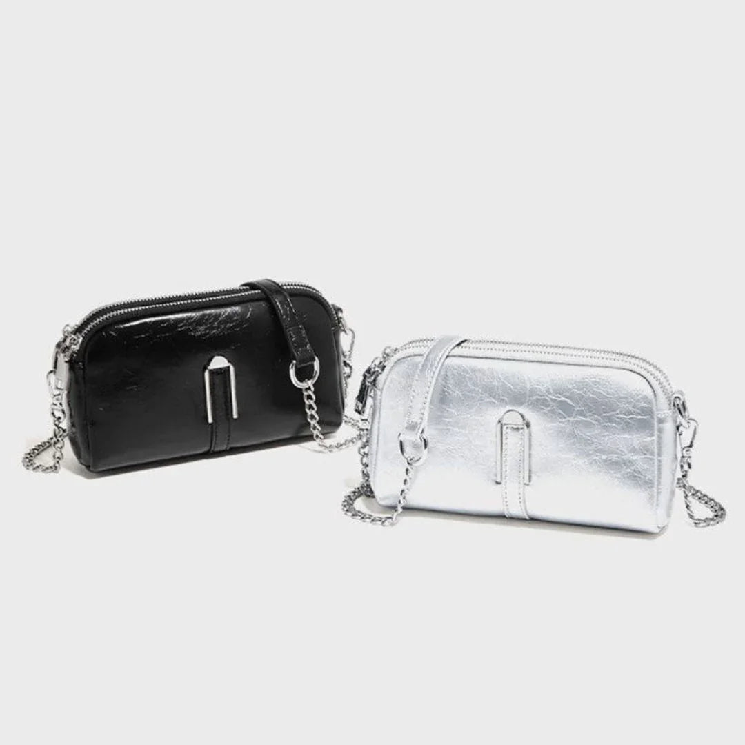 Black and silver crossbody handbags with chain straps on a white background