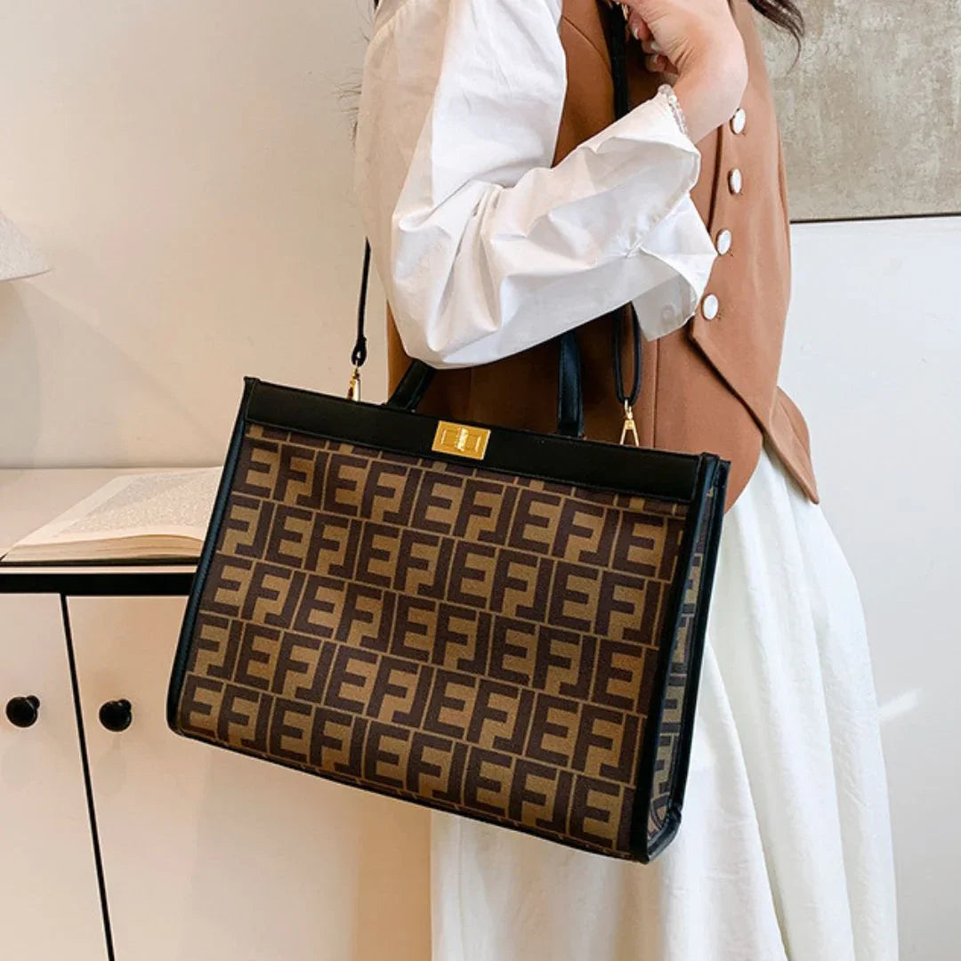 Woman in brown vest holding large brown F print designer handbag