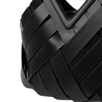 Close-up of modern black woven leather handbag with geometric design