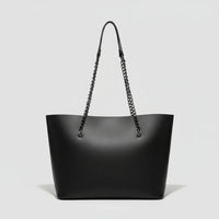 Black leather tote bag with chain shoulder straps on a plain white background.