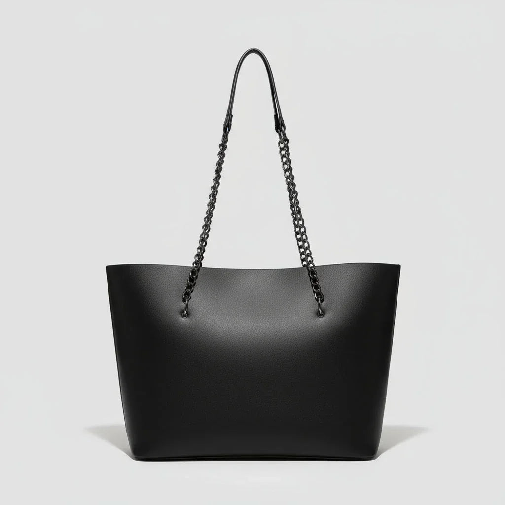 Black leather tote bag with chain shoulder straps on a plain white background.