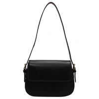 Black leather shoulder bag with flap closure and adjustable strap on white background