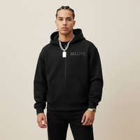 Black hoodie with 'BELIEVE' text on a gray background