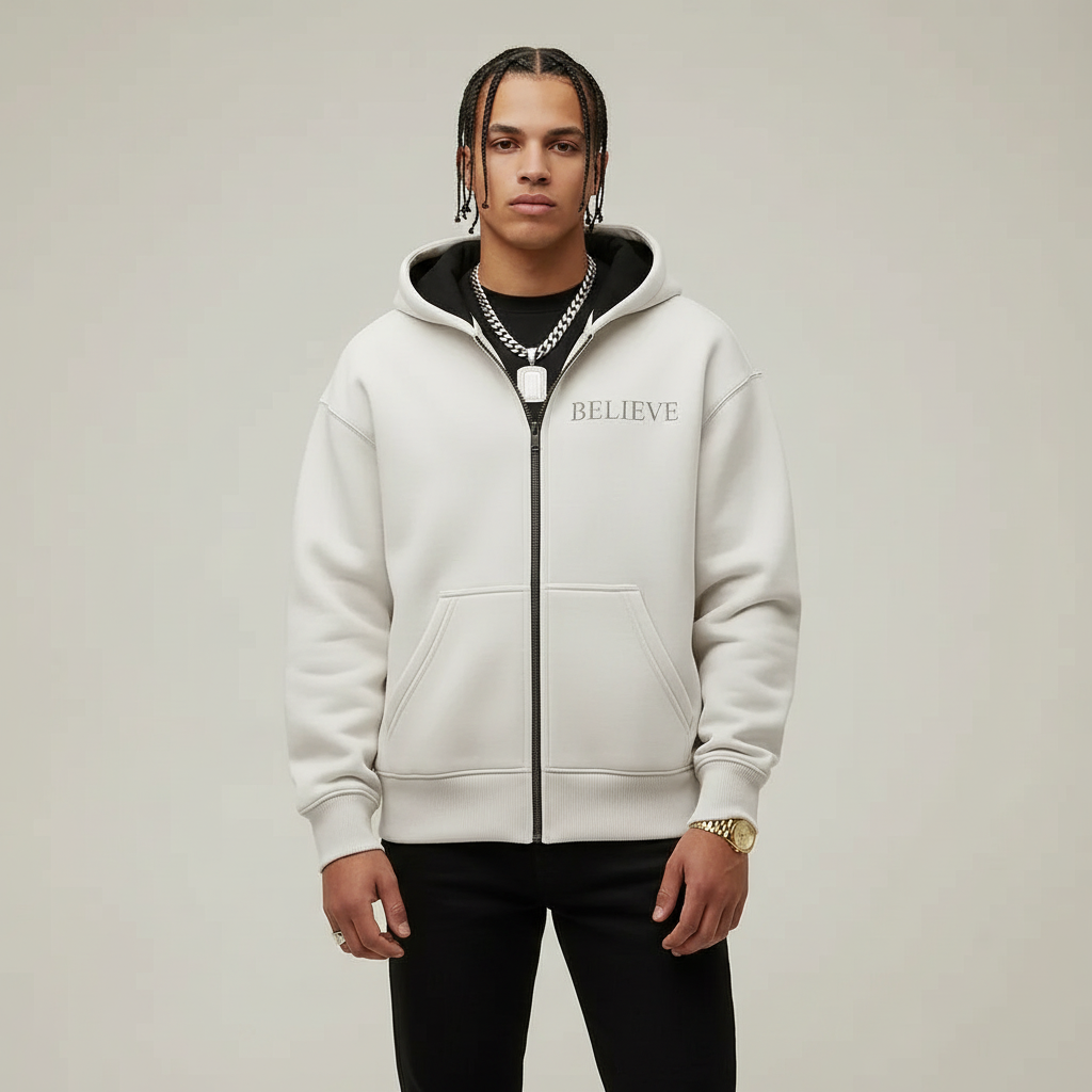 White hoodie with 'BELIEVE' text on a gray background