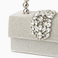 Silver crystal evening clutch bag with jeweled clasp and metallic handle on white background