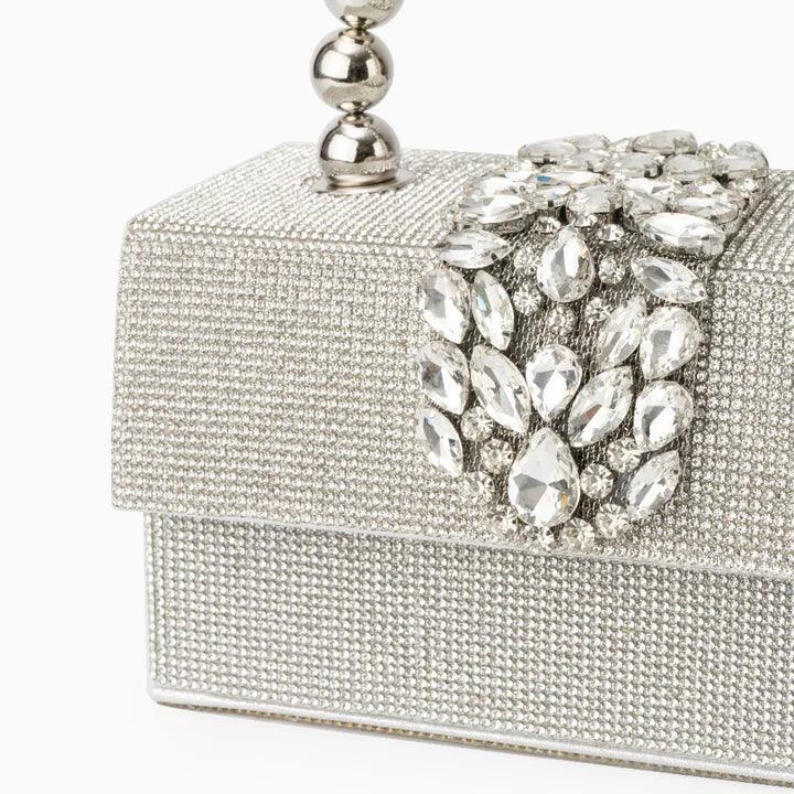 Silver crystal evening clutch bag with jeweled clasp and metallic handle on white background