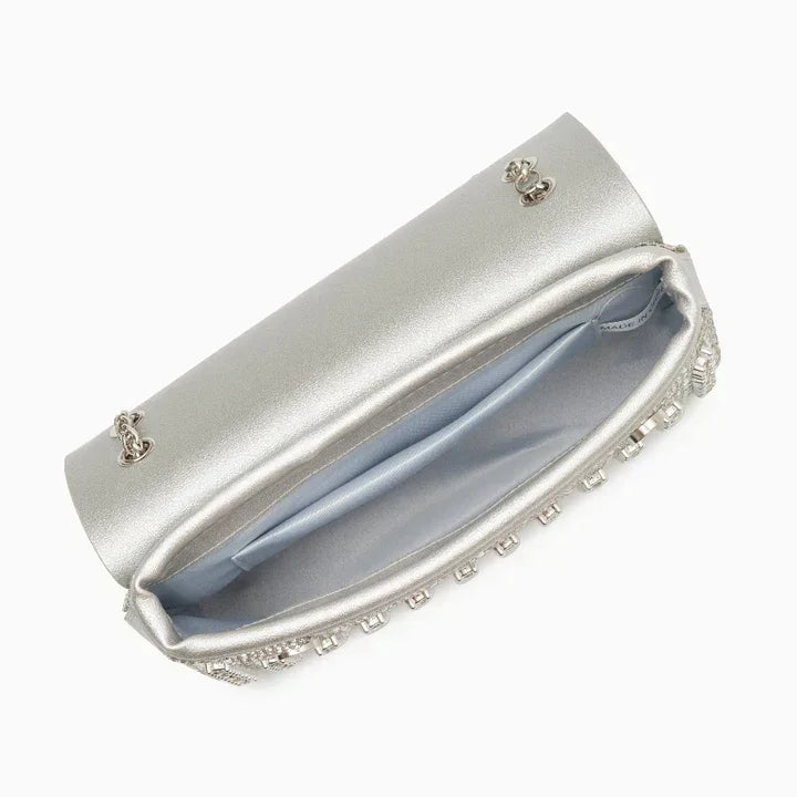 Open silver clutch bag with chain, satin lining, and rhinestone trim on white background