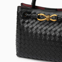 Black woven leather handbag with gold hardware and braided strap detail