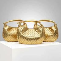 Three gold woven handbags with top handles displayed on a white pedestal