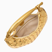 Gold woven leather handbag with knotted handle and beige fabric interior, top view