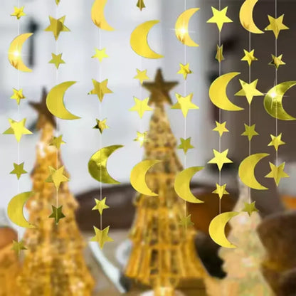 Decorative string with yellow stars and moons hanging in front of a blurred indoor background.