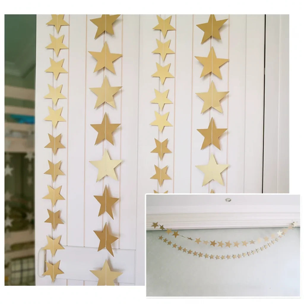 Gold star garland hanging on a white wall with a close-up of the stars.