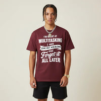 Person wearing a I'm Great at Multitasking burgandy t-shirt on a plain background