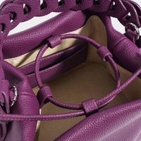 Interior view of purple leather bucket bag with beige lining and inner pocket