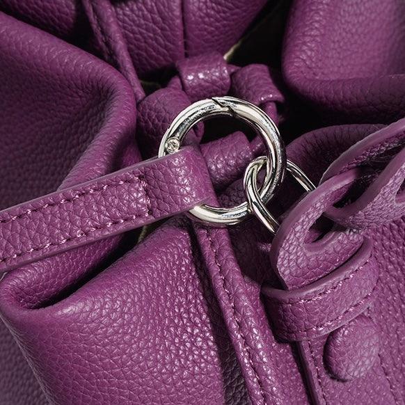 Close-up of purple leather handbag with silver ring detail