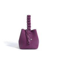 Purple leather bucket bag with braided handle on white background