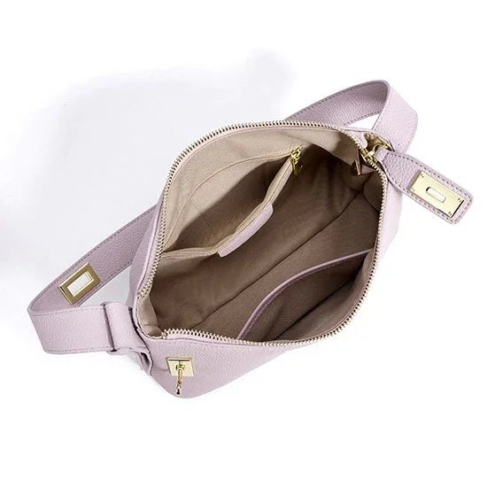 Open light lavender crossbody bag with beige interior and gold zipper accents on white background
