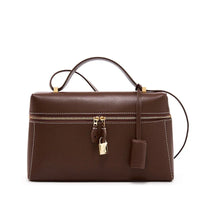 Brown leather handbag with gold zipper and lock, white stitching, and top handle
