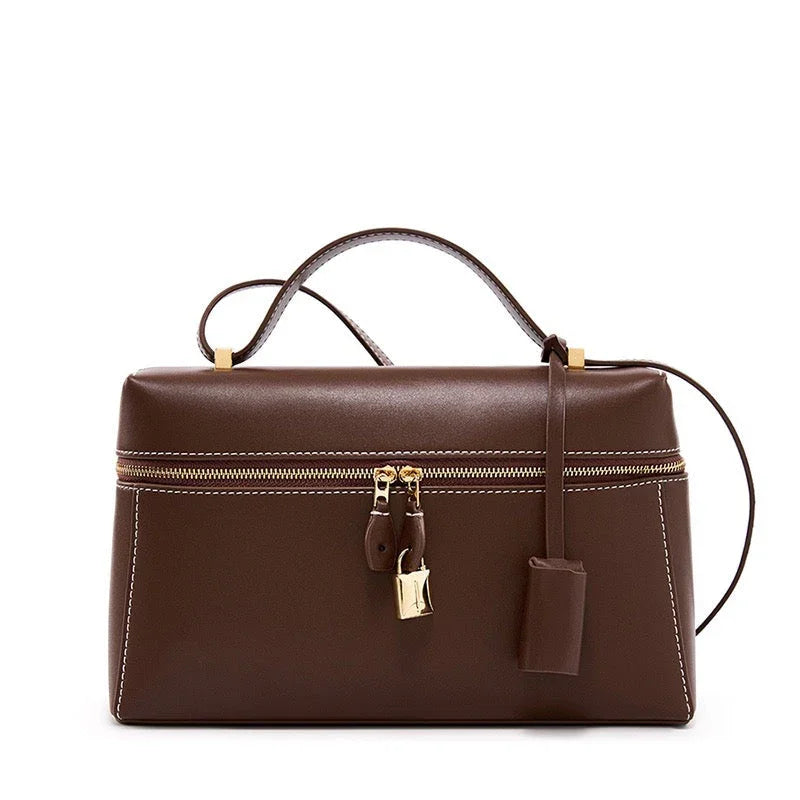 Brown leather handbag with gold zipper and lock, white stitching, and top handle
