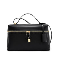 Black leather handbag with gold zipper, lock, and top handle.