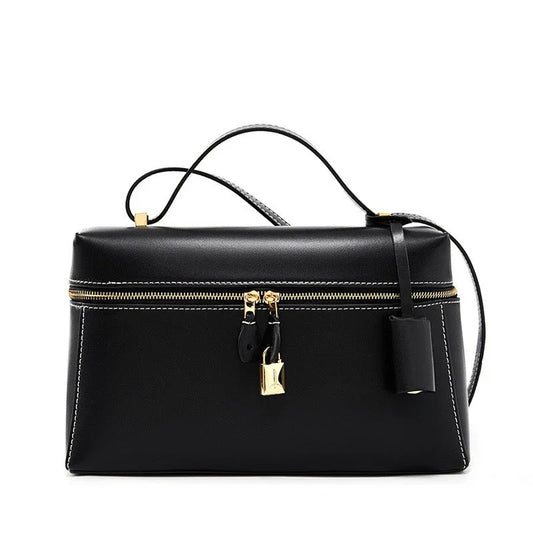 Black leather handbag with gold zipper, lock, and top handle.