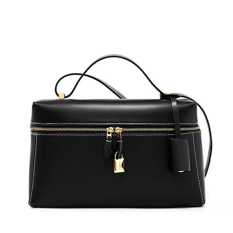 Black leather handbag with gold zipper, lock, and top handle.