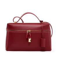 Red leather handbag with gold zipper and padlock, top handle, and white stitching