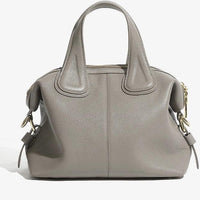 Taupe leather handbag with gold hardware and double handles on a white background