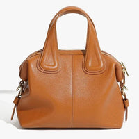 Brown leather handbag with gold hardware and short handles on white background